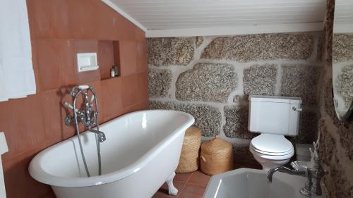 a bathroom with a white tub and a toilet at Casa da Carreira in Amarante