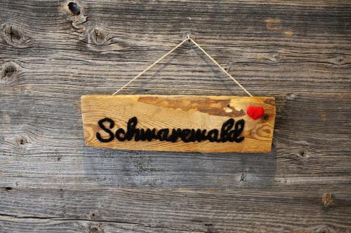 a wooden sign hanging on a wooden door at Hotel Kimmig in Bad Peterstal-Griesbach