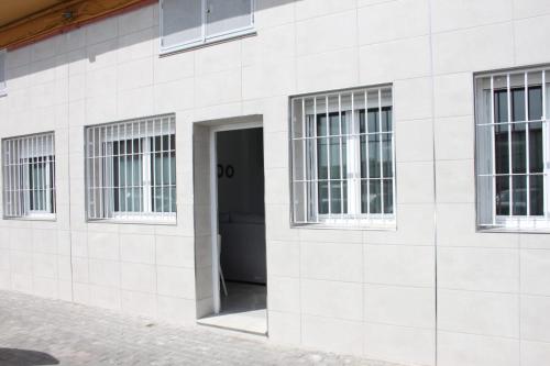 un edificio blanco con ventanas y una puerta en Apartamentos Margo 2 en Málaga