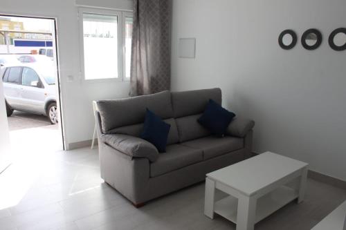 uma sala de estar com um sofá e uma mesa em Apartamentos Margo 2 em Málaga