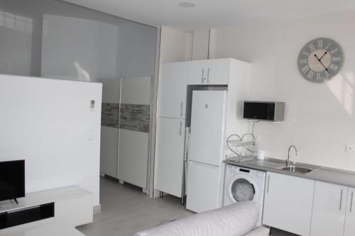 uma cozinha branca com um frigorífico e uma máquina de lavar louça em Apartamentos Margo 2 em Málaga