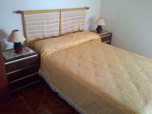 Un dormitorio con una cama con dos mesitas de noche y dos lámparas. en Alojamiento Doña Zule, en San José