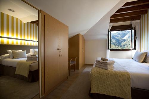 a hotel room with two beds and a window at Hotel La Casona de Llerices in Llerices