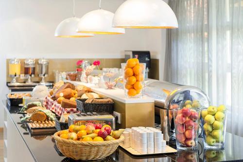 a buffet line with baskets of fruit and bread at Good Morning+ Hägersten in Stockholm