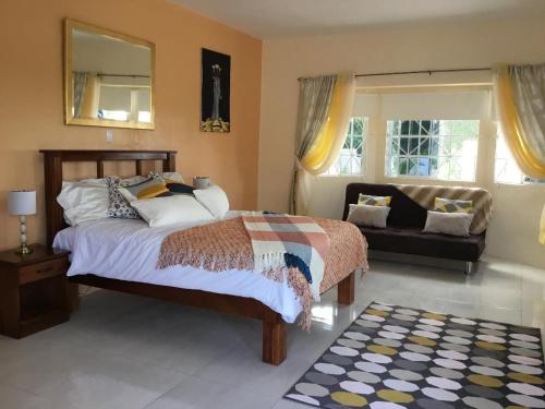 a bedroom with a bed and a couch and a mirror at Cool Breeze Discovery Bay in Discovery Bay