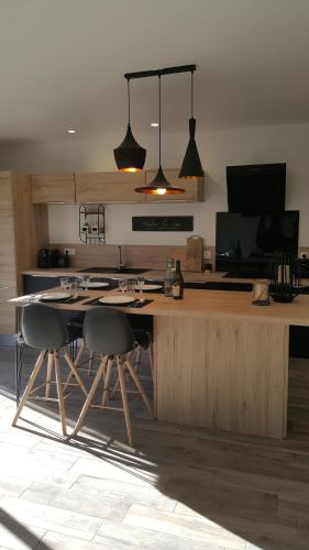 a kitchen with a counter with chairs and a table at MAISON FAMILIALE 3 ch. au CENTRE D'AX in Ax-les-Thermes