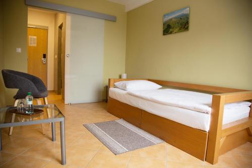 a bedroom with a bed and a glass table at Motel Skalka in Radola