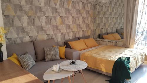 um quarto com uma cama, um sofá e uma mesa em BS Apartment Flatiron em Skopje