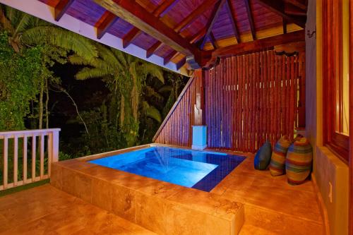 a small swimming pool on a patio with a roof at Sleeping Giant Rainforest Lodge in Belmopan