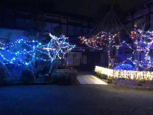 a house decorated with christmas lights in a yard at Minshuku Iwatakan in Takayama