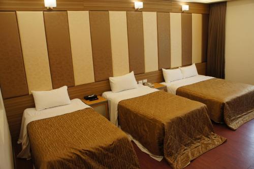 Pokój z 3 łóżkami i ścianą w paski w obiekcie Paris Motel w mieście Mailiao
