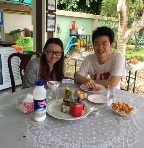 a man and a woman sitting at a table with food at Tum Baan Suan ตุ่มบ้านสวน in Chanthaburi