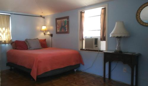 sypialnia z czerwonym łóżkiem i oknem w obiekcie 1 Beige Cozy Bungalow or 1 White Cozy Efficiency Cottage in Titusville w mieście Titusville