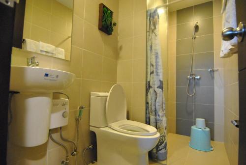 a bathroom with a toilet and a sink and a shower at One Madison Place Tower 1 in Iloilo City