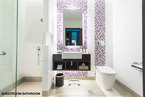 y baño con lavabo, aseo y espejo. en Astana Wing - Riverside Majestic Hotel, en Kuching