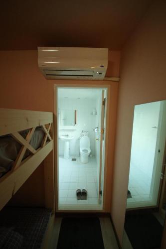 a small bathroom with a toilet and a bunk bed at Stitches House in Seoul