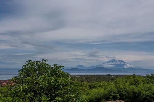 a view of a snow covered mountain in the distance at Bukit Taman Cottages in Nusa Lembongan