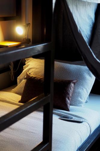 a bunk bed with pillows on top of it at Yu Cafe Hostel in Songkhla
