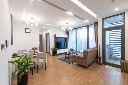 a living room with a table and chairs and a television at Hi-Home Suites - Vinhomes Metropolis in Hanoi
