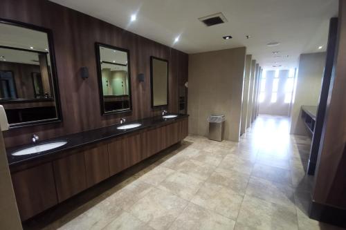 La salle de bains est pourvue de 2 lavabos et de 2 miroirs. dans l'établissement b.suites 21, à Kota Kinabalu