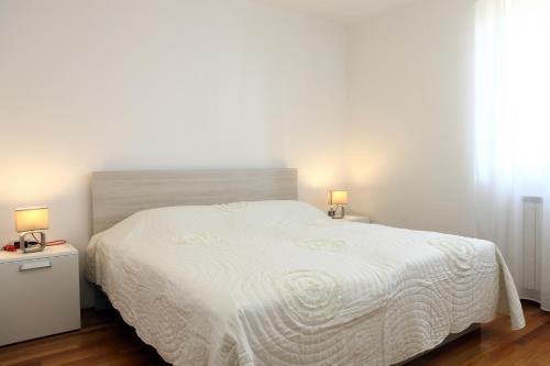 1 dormitorio con 1 cama blanca grande y 2 lámparas en Peaceful Apartment Ankaran SP, en Ankaran