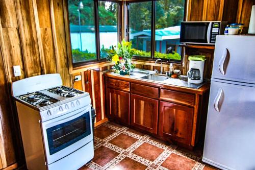 a kitchen with a stove and a refrigerator at Cabañas Hoja Verde in Monteverde Costa Rica