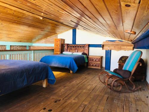 a bedroom with two beds and a wooden ceiling at Departamento tipo cabaña en Creel in Creel