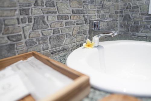 a bathroom with a sink with a flower on it at Astana House in Ubud