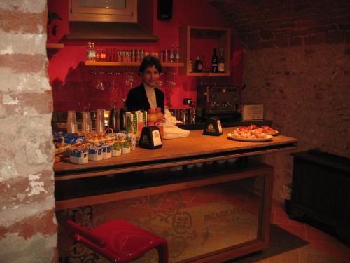 a woman standing behind a counter in a bar at Hotel Palazzo Di Mezzo in Carrù