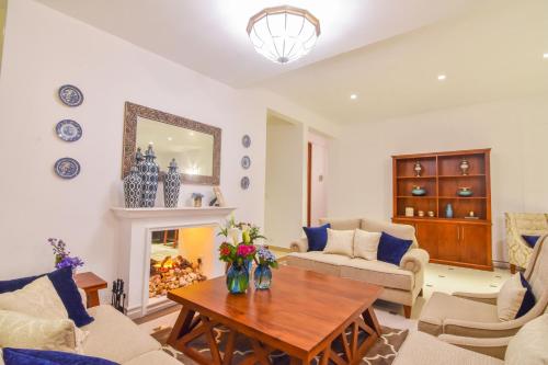 a living room with a table and a fireplace at The Lynden Grove in Nuwara Eliya