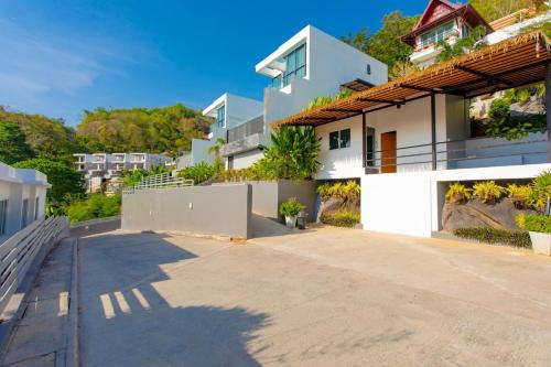 a white house with a pathway in front of it at Baan Saint-Tropez Seaview Villas Kata Beach in Kata Beach