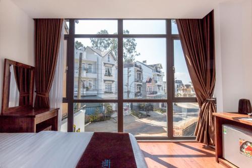 1 dormitorio con ventana grande con vistas a la calle en Villa Bảo Anh Dalat en Da Lat