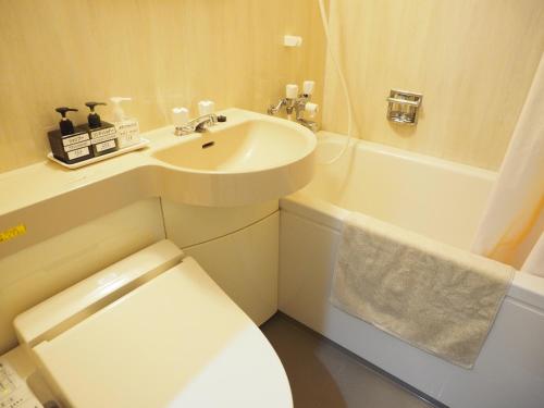 a bathroom with a sink and a toilet and a tub at Shin-Osaka Youth Hostel in Osaka