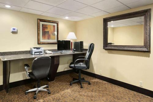 an office with a desk with two chairs and a mirror at Baymont by Wyndham Branson - On the Strip in Branson