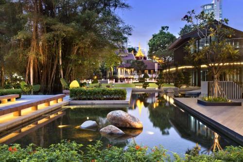 a pool with rocks in the middle of a garden at Days Hotel by Wyndham Singapore at Zhongshan Park in Singapore
