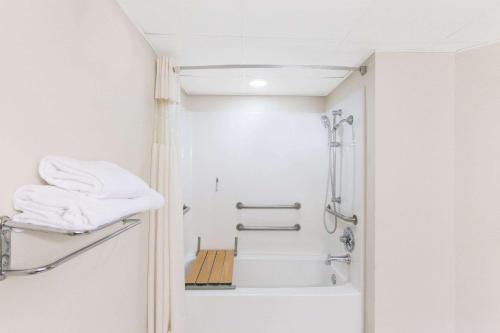 a bathroom with a shower and a bath tub at Baymont by Wyndham Branson - On the Strip in Branson