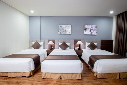 a group of four beds in a room at Muong Thanh Sapa Hotel in Sa Pa