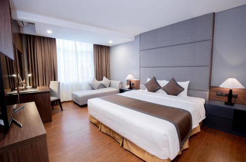 a hotel room with a large bed and a couch at Muong Thanh Sapa Hotel in Sa Pa