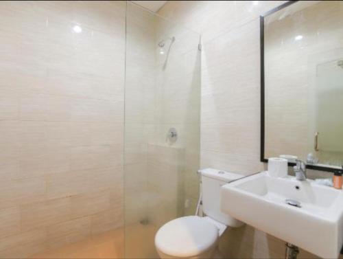 y baño con aseo, lavabo y ducha. en Hotel Sinar 2 en Sedati