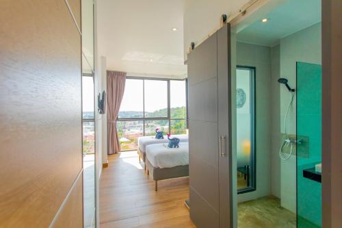 a bedroom with a bed and a large window at Baan Saint-Tropez Seaview Villas Kata Beach in Kata Beach