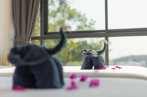 two toy elephants sitting on a table looking out of a window at Baan Saint-Tropez Seaview Villas Kata Beach in Kata Beach