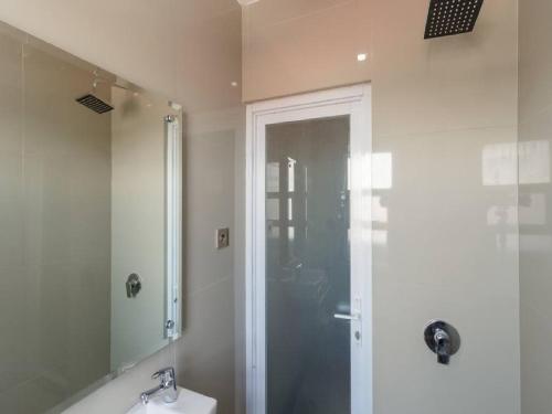 a bathroom with a shower and a toilet and a sink at RedDoorz Plus @ Boulevard Panakkukang in Makassar