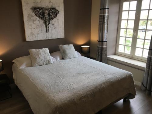 a bedroom with a bed and two windows at Logis Hôtel Le Moulin de Chalons in Le Gua