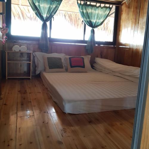a bed in a room with two windows at Tavan View Homestay in Sa Pa