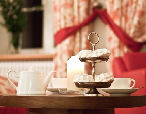 a table with a candle and cups and a candle holder at Pałac Pakoszów Schlosshotel Wernersdorf in Jelenia Góra