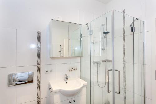 a white bathroom with a sink and a shower at Ferienwohnung Petersberg in Erfurt