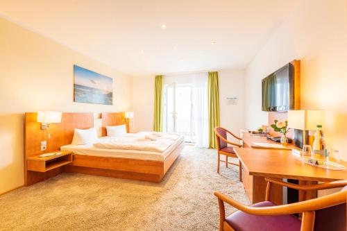 a hotel room with a bed and a desk at Hotel Königslinie in Sassnitz