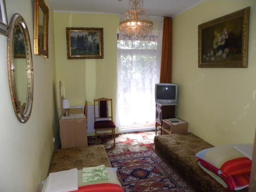 a room with two beds and a tv and a window at Dom Wypoczynkowy Admirał in Karpacz