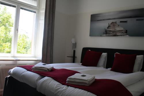 a bedroom with two beds with towels on them at Stadshotellet Kristinehamn in Kristinehamn