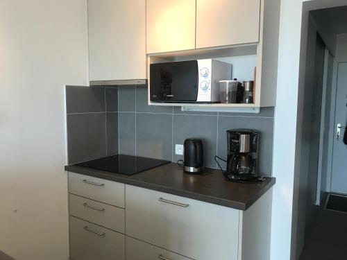 a kitchen with a counter top with a microwave at 50 Zeedijk in De Panne